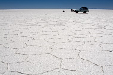 The ridges form as the salt crystallises from the evaporating water following the rains each year. Salar de Uyuni (or Salar de Tunupa) is the world's largest salt flat at 10,582 km² (4,085 square miles)[1]. It is located in the Potosí and Oruro departments in southwest Bolivia, near the crest of the Andes, 3,650 meters high. The major minerals found in the salar are halite and gypsum. Some 40,000 years ago, the area was part of Lake Minchin, a giant prehistoric lake. When the lake dried, it left behind two modern lakes, Poopó Lake and Uru Uru Lake, and two major salt deserts, Salar de Coipasa and the larger Uyuni. Uyuni is roughly 25 times the size of the Bonneville Salt Flats in the United States. Salar de Uyuni is estimated to contain 10 billion tons of salt, of which less than 25,000 tons is extracted annually. All miners working in the Salar belong to Colchani's cooperative. They work from dawn to dusk and most of them do not take a lunch break in order to take advantage of time, getting energy by chewing coca leaves. Every November, Salar de Uyuni is also the breeding grounds for three species of South American flamingos: the Chilean, James's and Andean flamingos. It is also a significant tourist destination; highlights include a salt hotel and several so-called islands. http://en.wikipedia.org/wiki/Salar_de_Uyuni
